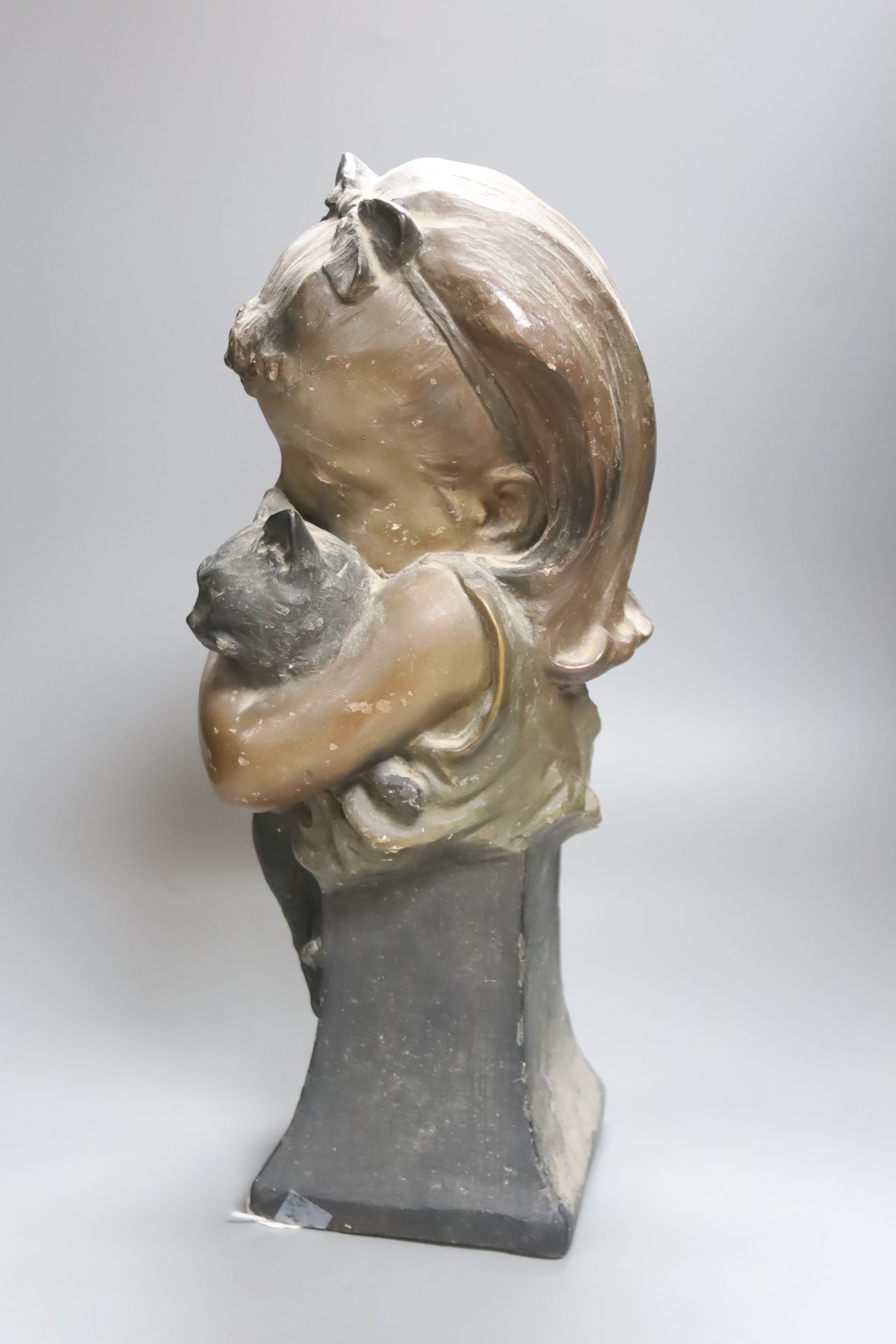 A plaster bust of a girl holding a cat, stamped CM, numbered 467, height 41cm